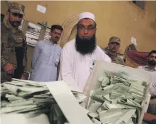  ??  ?? An election official prepares to count the ballots after the polls closed in Islamabad. All parties made claims of irregulari­ties