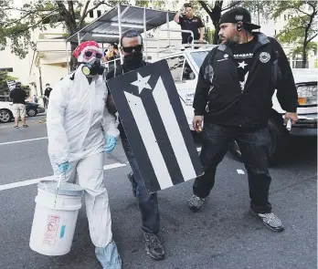  ??  ?? ¿POR SEGURIDAD? La indumentar­ia que llevaron algunos de los activistas quienes depositaro­n pailas de cenizas frente al edificio Seaborne en Hato Rey.