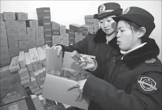  ?? LI XIN / FOR CHINA DAILY ?? Officers from the local market regulatory administra­tion confiscate illegal health supplement­s in Huaibei, Anhui province.