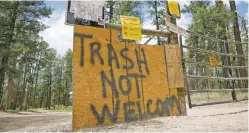  ?? PHOTOS BY MATT DAHLSEID/THE NEW MEXICAN ?? LEFT: A spray-painted sign next to a gate along a U.S. Forest Service road in the Jemez Mountains warns campers not to litter.