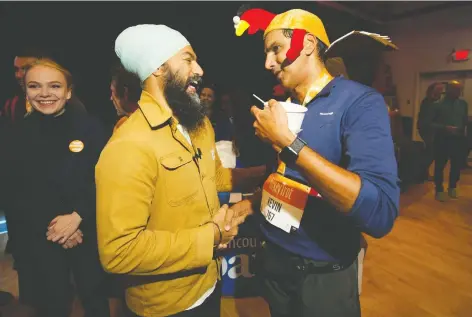  ?? ARLEN REDEKOP ?? NDP Leader Jagmeet Singh says hello to Kevin Koonar on a visit to Granville Island during the Turkey Trot run on Monday. He also stocked up on boxes of doughnuts he planned to take to striking hotel workers at his next campaign stop outside the Westin Bayshore.