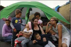  ?? AP PHOTO/GREGORY BULL ?? In this Nov. 8 photo, Christine Wade sits among her children in front of their donated tent in the city-sanctioned encampment on a parking lot in San Diego. They are (from left), Shawnni, 12, Roland, 4, Rayahna, 3, Jaymason, 2, Brooklyn, 8, and...