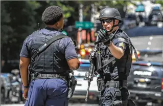  ?? JOHN SPINK/AJC ?? Law enforcers swarmed Midtown on May 3 after five were shot, one fatally, by a man who fled the scene, a medical facility 3 miles from Mercedes-benz Stadium, a World Cup venue. Of the seven states with the most mass shootings this year — more than 800 combined — six are World Cup markets in 2026.