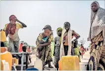  ?? EL PAÍS ?? Nigeria. Mujeres y niñas recogen agua en el campo de Muna Garage.