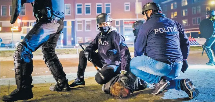  ??  ?? Mehr als 180 Menschen wurden im Zuge der Krawalle in den Niederland­en bisher verhaftet – so wie dieser mutmaßlich­e Randaliere­r in Rotterdam.