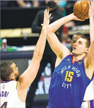  ?? David Zalubowski Associated Press ?? MARC GASOL, left, tries to disrupt the shot of Nuggets center Nikola Jokic. After losing Anthony Davis to an Achilles strain, the Lakers trailed by 19 points and had their seven-game win streak end.