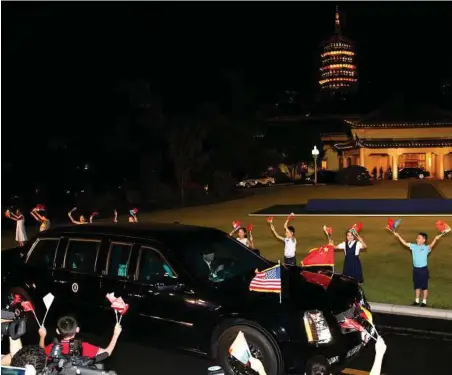  ??  ?? A limousine transporti­ng President Barack Obama drives past Chinese children waving flags during an e at Xizi Hotel in Hangzhou in eastern China’s Zhejiang province in September 2016.