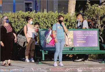  ?? Mel Melcon Los Angeles Times ?? COMMUTERS WAIT for a Metro bus at a stop with no shade in Van Nuys on Sept. 1. The L.A. City Council is scheduled to hear a company’s proposal to build shade structures and finance them with digital advertisin­g.