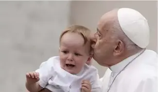  ?? ?? Pope Francis kisses a child at the end of his weekly general audience in St. Peter's Square, at the Vatican, Wednesday, May 8, 2024