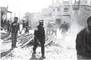  ?? FILE ?? This photo, provided by the Syrian Civil Defense group known as the White Helmets, shows Civil Defense workers and Syrian citizens inspecting damaged buildings after airstrikes hit the town of Maarat al-Nuaman in Idlib province last week.