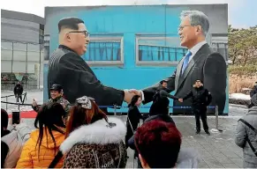  ?? AP ?? People take pictures using an image of North Korean leader Kim Jong Un, left, and South Korean President Moon Jae-in as a backdrop at a park near the presidenti­al Blue House in Seoul.