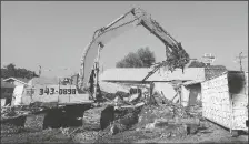  ?? PHOTO BY RANDY HOEFT/YUMA SUN ?? A YUMA DEMOLITION HYDRAULIC excavator prepares to drop a load of debris into a dumpster last Friday during the demolition of iconic Yuma restaurant Jack ‘n Rosie’s.