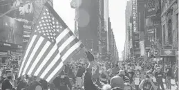  ?? SETH WENIG/AP ?? People celebrate in Times Square in New York on Saturday after former vice president and Democratic presidenti­al candidate Joe Biden was announced as the winner over Pres. Donald Trump to become the 46th president of the United States.