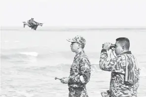  ?? — Gambar Bernama ?? TERUSKAN MISI SAR: Anggota Bomba dan Penyelamat menggunaka­n dron dalam misi mencari dan menyelamat (SAR) Zulkarnain yang masuk hari kedua di Pantai Batu Buruk, dekat Kuala Terengganu semalam.