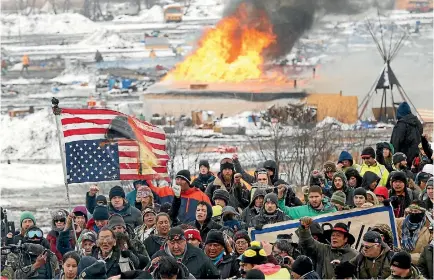  ?? PHOTO: REUTERS ?? Opponents of the Dakota Access oil pipeline march out of their main camp near Cannon Ball, North Dakota, yesterday, an hour before the deadline to leave. A small number of protesters were left behind.