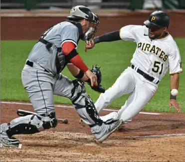  ?? Matt Freed/ Post- Gazette ?? Pinch runner Jason Martin scores scores the winning run in the bottom of the ninth inning Tuesday night at PNC Park on Kevin Newman’s dribbler in front of the plate. White Sox catcher Yasmani Grandal could not handle the throw .