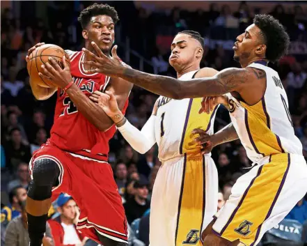  ??  ?? No way through: Chicago Bulls’ Jimmy Butler (left) is stopped from going forward by Los Angeles Lakers’ D’Angelo Russell (centre) and Nick Young during their NBA game on Sunday. — AP