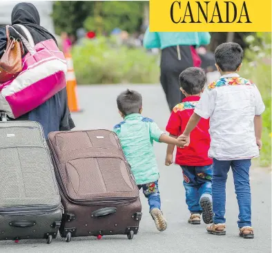  ?? GEOFF ROBINS/AFP/GETTY IMAGES ?? Asylum seekers walk along a road near Champlain, N.Y., this month, making their way toward the Canada-U.S. border.