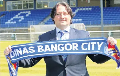  ?? David Powell ?? New Bangor City FC boss Craig Harrison poses for the traditiona­l photograph with a club scarf.