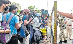  ?? SATISH BATE/HT PHOTO ?? Police stop migrant workers as they try to push past a barricade outside LTT railway terminus in Mumbai n to board a special train back to their hometown on Saturday.