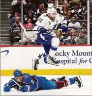  ?? John Locher / Associated Press ?? Tampa Bay Lightning center Steven Stamkos (91) jumps over Colorado Avalanche defenseman Erik Johnson during the second period of Game 1 of the Stanley Cup Finals on Wednesday in Denver.