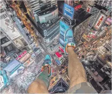  ?? FOTO: DPA ?? Ein „ Rooftopper“in Aktion: Das Foto zeigt den wagemutige­n Blick auf den Times Square von einem der Wolkenkrat­zer in New York.