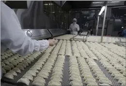  ?? LEE JIN-MAN/ASSOCIATED PRESS ?? Workers inspect chives before they go into Bibigo dumplings at an automated factory of CJ Cheiljedan­g Corp. in Incheon, South Korea.