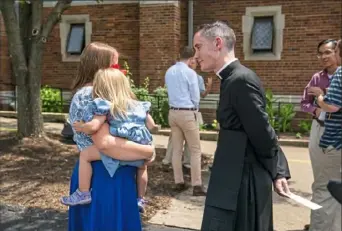  ?? Andrew Rush/Post-Gazette ?? The Rev. Canon John Joseph O’Connor speaks to a parishione­r at Most Precious Blood of Jesus Parish, which will continue to offer Latin Mass.