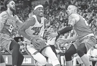  ?? LYNNE SLADKY/AP ?? Heat forward Jimmy Butler drives to the basket between Celtics guard Derrick White, left, and center Daniel Theis during Game 1 of the Eastern Conference finals on Tuesday in Miami.