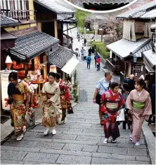  ?? ?? Visitors dressed in traditiona­l Japanese garb walk one of the streets leading to the Kiyomizu-dera temple