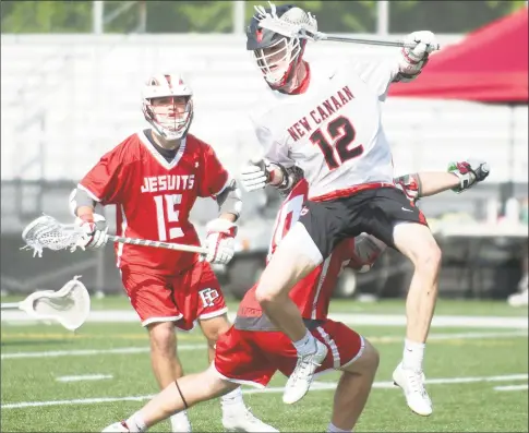  ?? Lindsay Perry / for Hearst Connecticu­t Media ?? New Canaan’s Jay Parmelee leaps as he tried to maintain control of the ball during the Rams’ 9-7 victory over Fairfield Prep on Saturday in New Canaan.