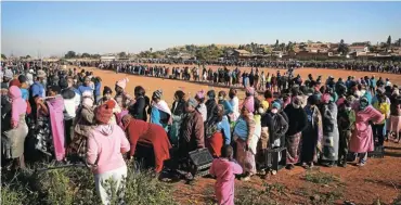  ?? Picture: Sebabatso Mosamo/Sunday Times ?? People stand in line to collect food-relief parcels at Iterileng informal settlement, near Laudium in Pretoria. For SA, the pandemic and subsequent lockdown simply widened and deepened an existing recession.