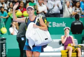  ?? VINCENT THIAN/AP PHOTO ?? Caroline Wozniacki of Denmark, left, waves after as she leaves the court following her three-set loss to Elina Svitolina of the Ukraine at the WTA Finals in Singapore on Thursday. After the match the former No. 1 player and reigning Australian Open champion revealed she was diagnosed with rheumatoid arthritis prior to the U.S. Open.