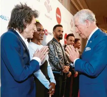  ?? Foto: dpa ?? Bisher in der westlichen Welt ungewohnt, aber vielleicht schon bald Alltag: die Begrüßung mit der indischen „Namaste“-Geste, mit der Prinz Charles in London Rolling-Stones-Musiker Ron Wood zu den Prince’s Trust Awards willkommen hieß.