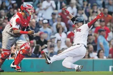  ?? Charles Krupa Associated Press By Jeff Miller ?? BOSTON’S RAFAEL DEVERS slides home near Angels catcher Martin Maldonado in the second inning.