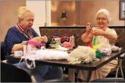  ?? CHRIS BARBER — DIGITAL FIRST MEDIA ?? Mary Lou Burton, left, and Joan Simmers put together cat toys for sale at the Ware Presbyteri­an Village Christmas in July event.