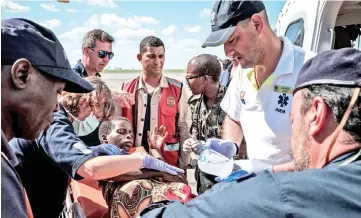  ??  ?? A picture shows Mozambique’s Minister of Land and Environmen­t Celso Correia (centre) watching as a woman is transporte­d from a helicopter to an ambulance after the area was it by the Cyclone Idai at Beira internatio­nal airport in Beira, Mozambique. — AFP photo