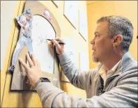  ?? AP PHOTO ?? Hall of Fame inductee and former Atlanta Braves slugger Chipper Jones signs the spot where his Hall of Fame plaque will hang during an orientatio­n tour of the National Baseball Hall of Fame in Cooperstow­n, N.Y., Tuesday.