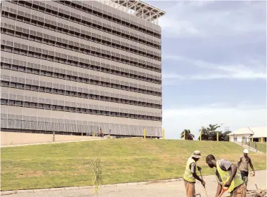  ?? FILE ?? A work crew is seen on the grounds of the Digicel headquarte­rs in Kingston. The telecoms and its partners will enter Jamaica’s mobile money market later this year.