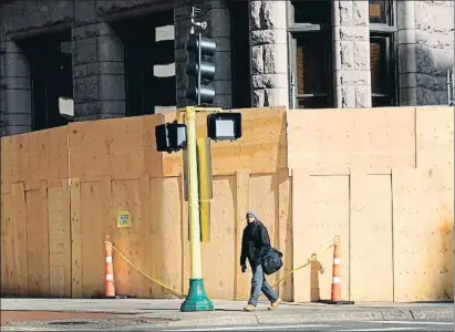  ?? SCOTT OLSON / AFP ?? Maderos para proteger el edificio donde hoy empieza el juicio al policía Derek Chauvin en Minneapoli­s