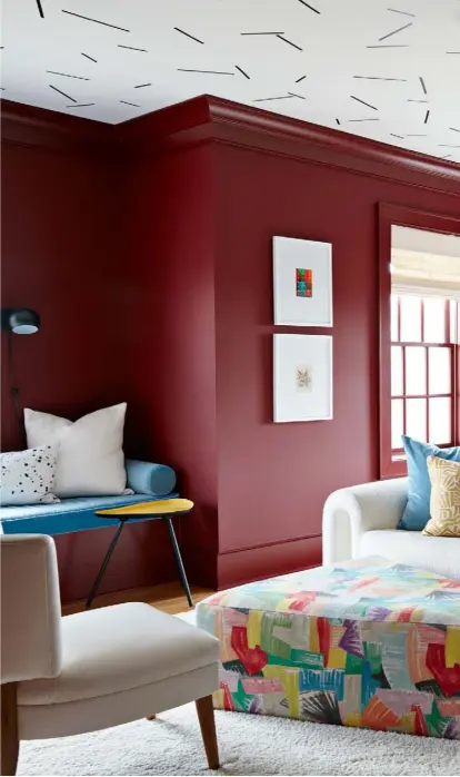  ??  ?? Living room Angela’s art spills onto the walls, with the ceiling painted in a confetti design. A triangular ottoman by a local carpenter is upholstere­d in ‘Aimee’ fabric by Clarence House, while the more neutral vintage sofa is from Gillian Bryce Fine Art