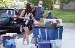  ?? H John Voorhees III / Hearst Connecticu­t Media file photo ?? Kalynna Hauser, of Orange, a junior nursing student, left, gets help from her father, Greg Hauser, as she moved into a Western Connecticu­t State University dorm last August. Despite the latest surge in COVID cases, Connecticu­t’s state college and university system plans to open for the spring semester as scheduled and in person.