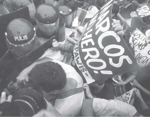 ?? PHOTO COURTESY OF MARK DEMAYO / ABS-CBN NEWS ?? Protesters hustle against riot police outside the Libingan ng mga Bayani in Taguig City while the Marcos family commemorat­es the 100th birthday of the late dictator Ferdinand Marcos Sr. on Monday, Sept. 11.
