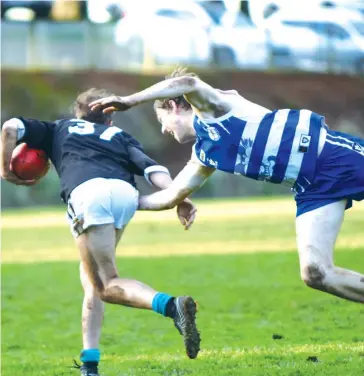  ??  ?? Yarragon’s Lachlan Shaw breaks away from the desperate tackling effort of Jeremiah Jones.