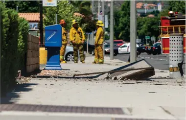  ?? Austin Dave/The Signal (See additional photos at signalscv.com) ?? Emergency responders assess the scene on the sidewalk near the Valencia Lanes bowling alley on Tuesday afternoon. An undergroun­d explosion prompted the concrete to buckle.