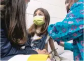  ?? DUKE HEALTH VIA AP ?? Alejandra Gerardo, 9, looks to her mom Wednesday as she gets the first of two Pfizer COVID-19 vaccinatio­ns during a clinical trial for children at Duke Health in Durham, North Carolina.