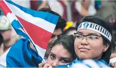  ?? FOTO: EZEQUIEL BEZERRA / AGENCIA AFP ?? Una nicaragüen­se carga una bandera de Costa Rica en San José.