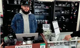  ?? RAY STERN/THE REPUBLIC ?? Abel Ochoa helps a customer at his independen­t El Mirage dispensary, which he operates under a state social equity license.