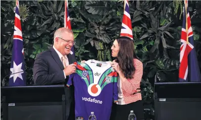  ?? PHOTO: GETTY IMAGES ?? Just for you . . . Australian Prime Minister Scott Morrison is presented with a New Zealand Warriors jersey by his New Zealand counterpar­t, Jacinda Ardern, after holding a joint press conference at Government House in Auckland yesterday.