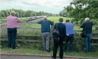  ?? TONY MILES ?? Crowds turned out at stations and linesides along the route to cheer on the special, including this group of enthusiast­s at Winwick Junction, Cheshire.